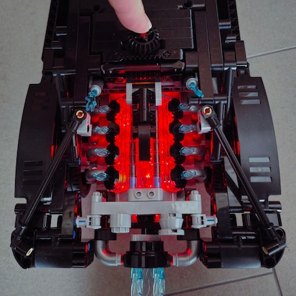 Der Motor hinten leuchtet rot auf, wenn du auf das Lenkzahnrad auf dem Dach drückst.