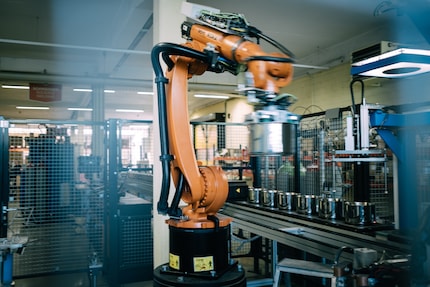 Ein Roboterarm schweisst Noppen an die richtige Stelle. Es ist einer der wenigen automatisierten Arbeitsschritte.