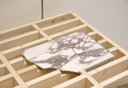 De regelmatige, monochrome rasterstructuur laat de unieke stukken nog meer opvallen.