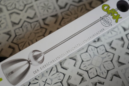 «Eierschalensollbruchstellenverursacher» - de tongbreker «siert» de verpakking en de gadget zelf.