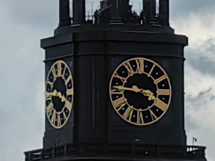 Vijfvoudig inzoomen brengt de wijzerplaat van de kerk in beeld, maar het ziet er niet echt mooi uit.
