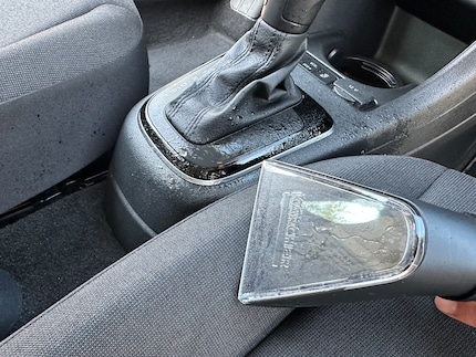 Ik moet voorzichtig zijn als ik het meubelmondstuk op gebogen oppervlakken gebruik. Omdat ik hier niet voorzichtig genoeg was, heb ik schoonmaakmiddel op de middenconsole gespat.