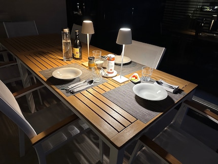 Die Poldina Pro beleuchtet den Terrassentisch bei einem späten Familien-Abendessen.