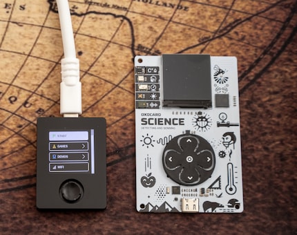 De Oxocard Connect (links) is veel kleiner dan de Oxocard Mini. De joystick is lastiger te gebruiken dan de grote richtingsknoppen.