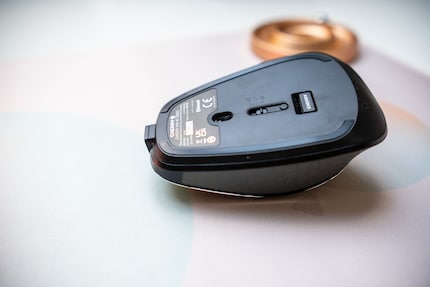 De dongle voor de draadloze verbinding wordt magnetisch aan de onderkant van de muis bevestigd.