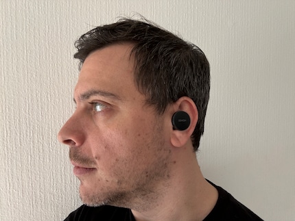 Ein breiter, runder Badge ragt aus meinem Ohr