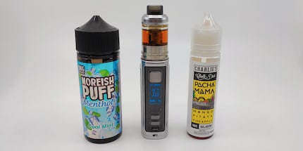 Mijn e-cig lichtzwaard omringd door vloeistoffen om bij te vullen.