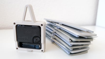 Het uurwerk links, de insteekonderdelen rechts. Een papiertje tussen de afzonderlijke onderdelen voorkomt dat er krassen op komen tijdens het transport.