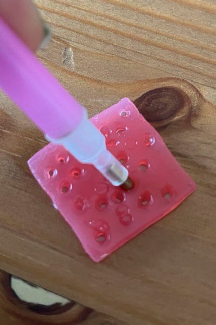 Ik druk de applicator in de was zodat de diamanten eraan blijven plakken.