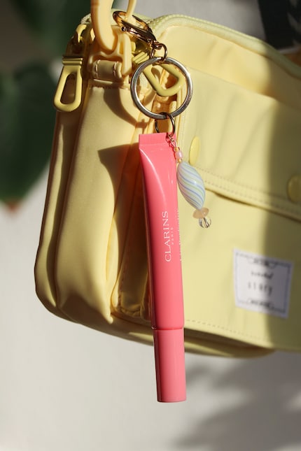 Mit einem Karabinerhaken lässt sich der Gloss unkompliziert an Tasche, Schlüsselbund und Co. hängen.