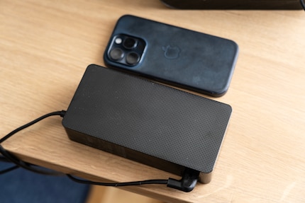 Externe voedingen maken lichtere apparaten mogelijk. Maar ik moet er wel een plekje voor vinden op tafel. Ter vergelijking een iPhone 15 Pro ernaast.