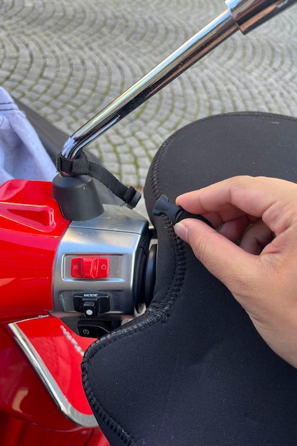Om te voorkomen dat hij er tijdens het rijden afvliegt, is hij met een kliksluiting aan de zijspiegel bevestigd.
