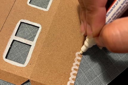 Ik teken het dak of de tekeningen op de muren van het huis met een witte Sharpie. 