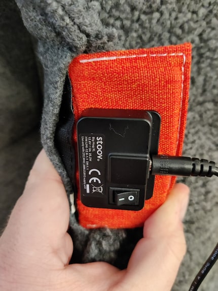 Aan de achterkant kun je de verwarmingsdeken via een kabel aansluiten en aan- en uitzetten.