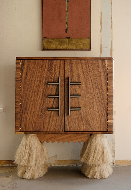 It combines carved wood and hand-turned metal handles.