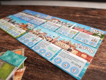 Acht dubbelzijdige stadsplattegronden voegen variatie toe aan het spel.