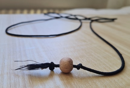 Mijn aangepaste versie voor Jasper: een houten kraal in plaats van een muis aan het rubberen koord.