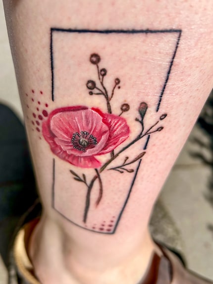 De klaproosbloem op mijn rechterbeen gloeit.