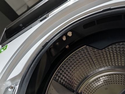 The two white nozzles are located at the top of the door frame.